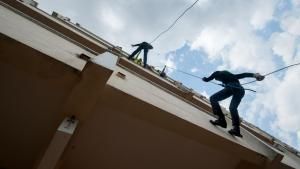 Two people scaling a building