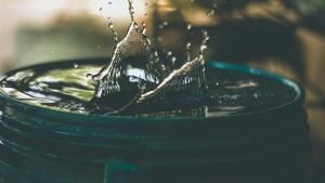 Photo of a barrel full of water after something was dropped in, causing a splash - photo by Amritanshu Sikdar