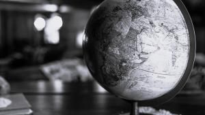 globe sitting on a desk in the foreground with an out-of-focus background